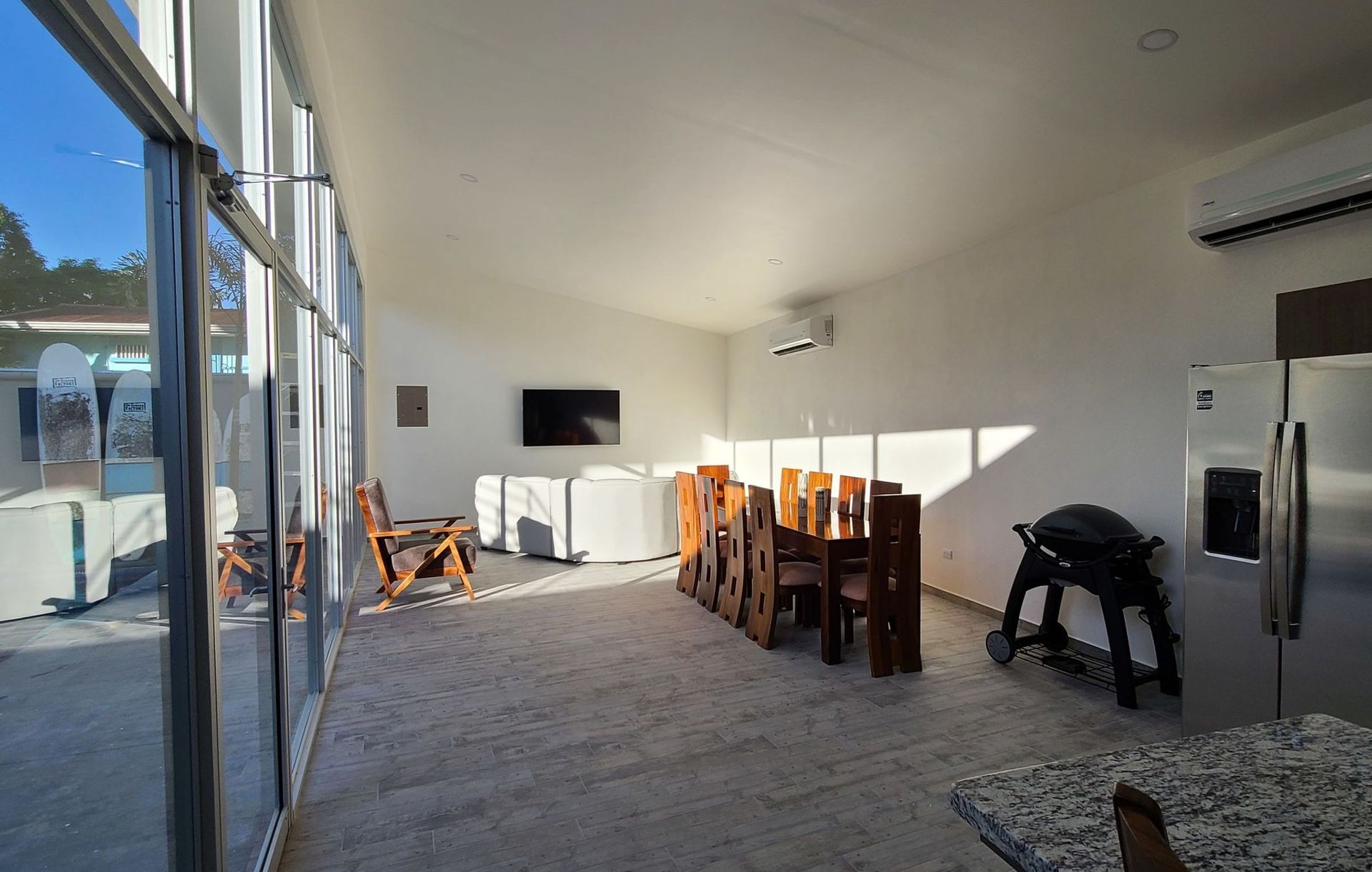 A large room with a lot of windows and a refrigerator.