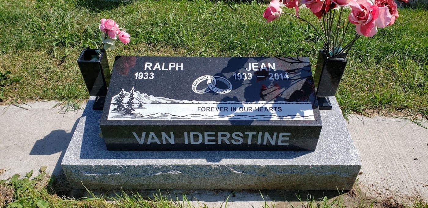 Tombstone with names Ralph and Jean Van Iderstine, born 1933 and 1939, died 2014. Pink flowers in vases.