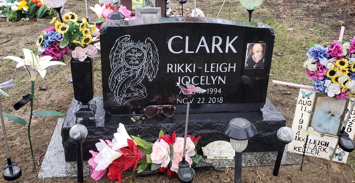 Black headstone with flowers; 