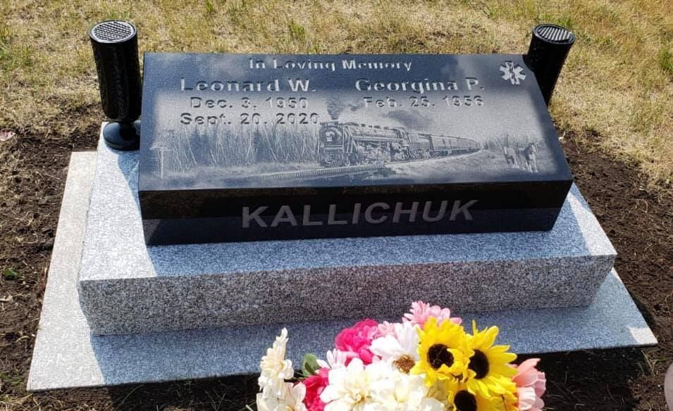 Gravestone for Leonard W. and Georgina P. Kallichuk, featuring an etched train scene, with flowers in front.