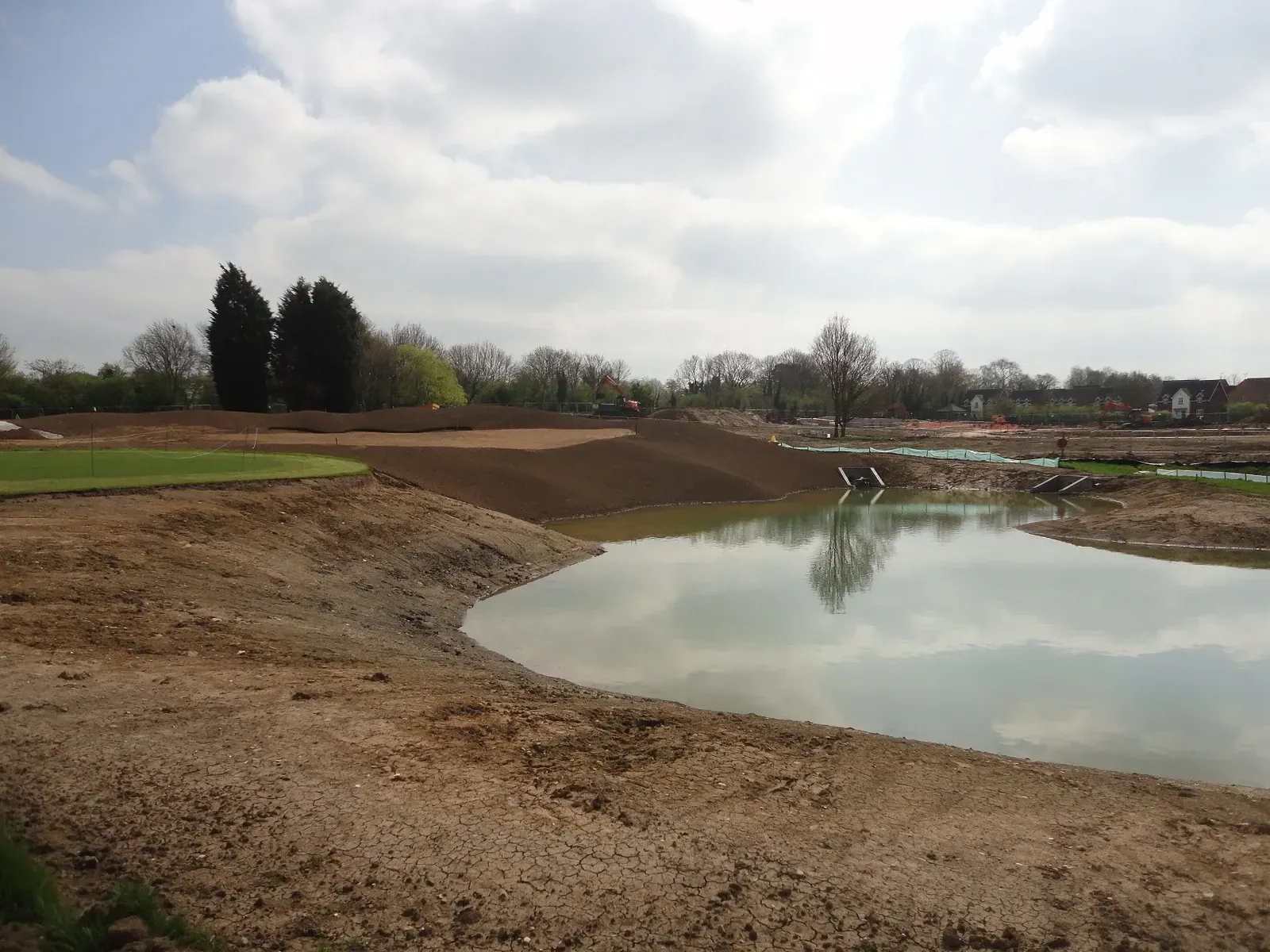 Attenuation pond under construction at edge of golf course