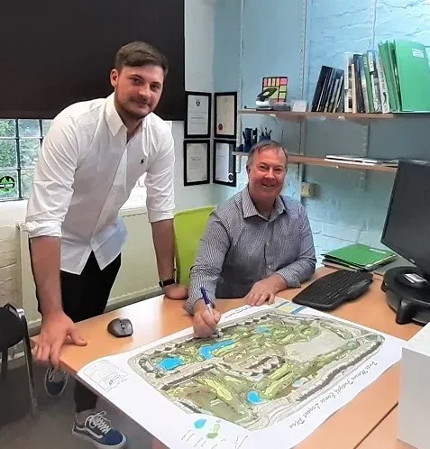 Steve sitting at golf course drawing in office