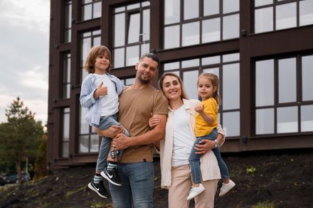 A man and a woman are playing with a dog in a room.