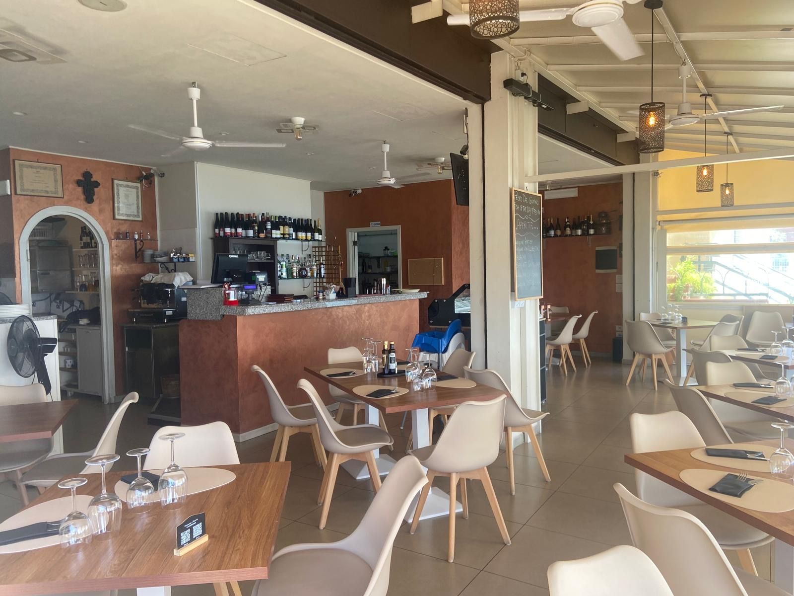 Un ristorante con tavoli e sedie e un bar