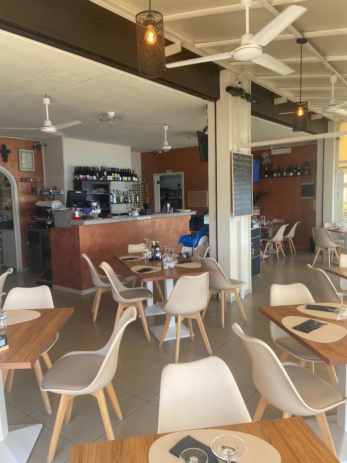 Un ristorante con tavoli e sedie e un bar