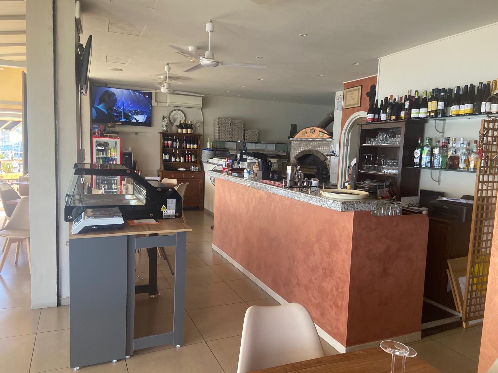 Un ristorante con tavoli e sedie e un bar