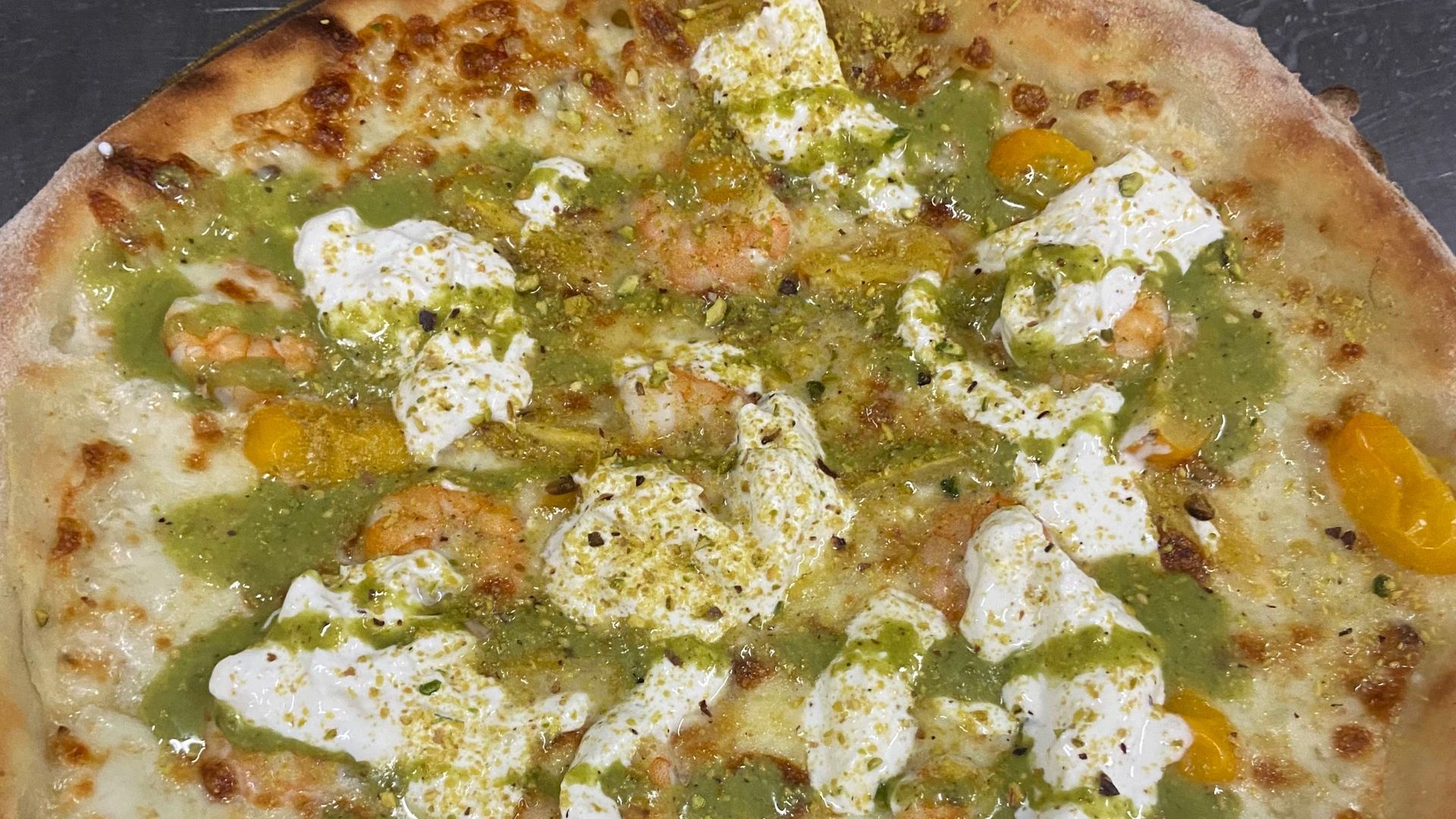 Una pizza con tanti condimenti è appoggiata su un tavolo.