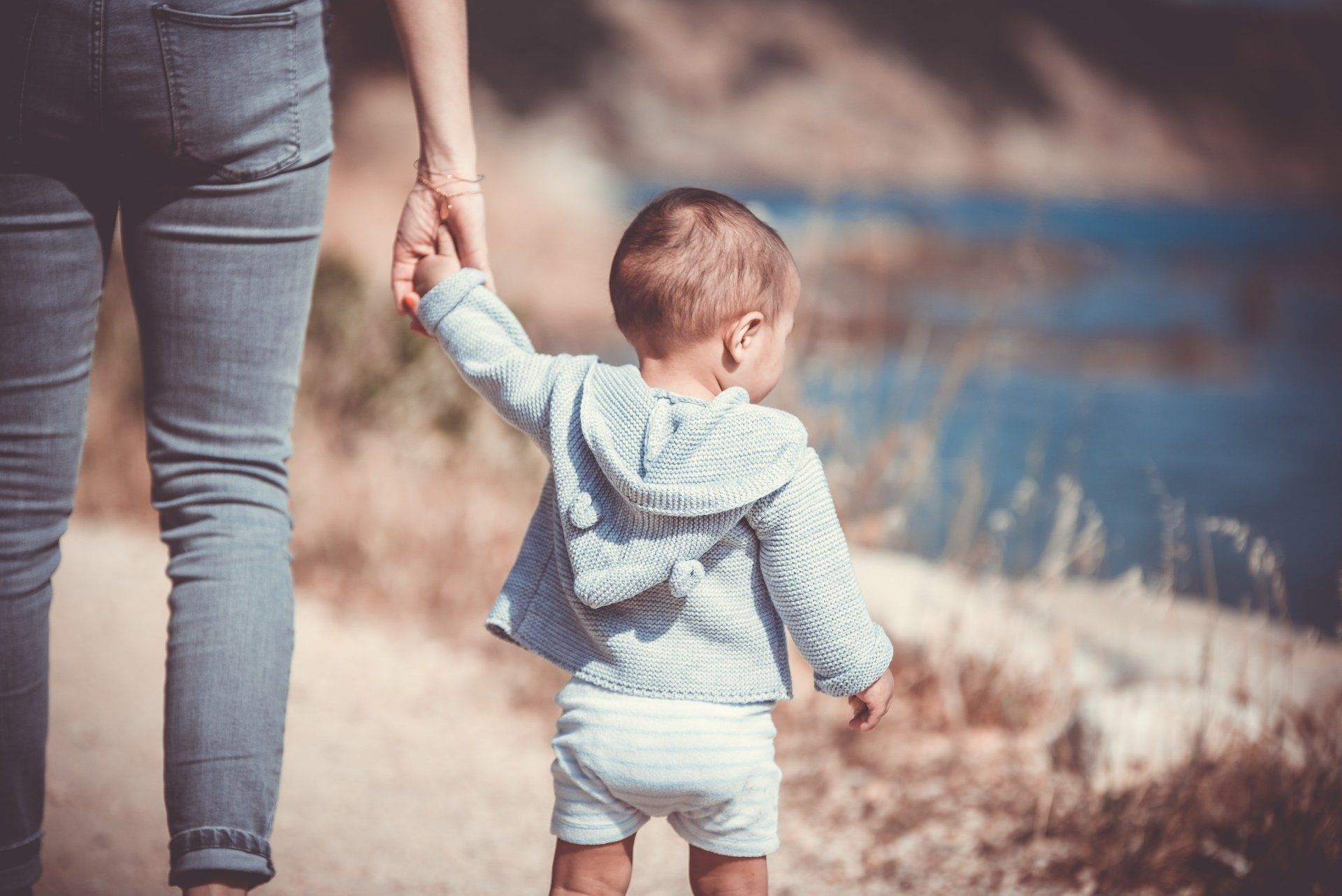 Toddler walking with adult