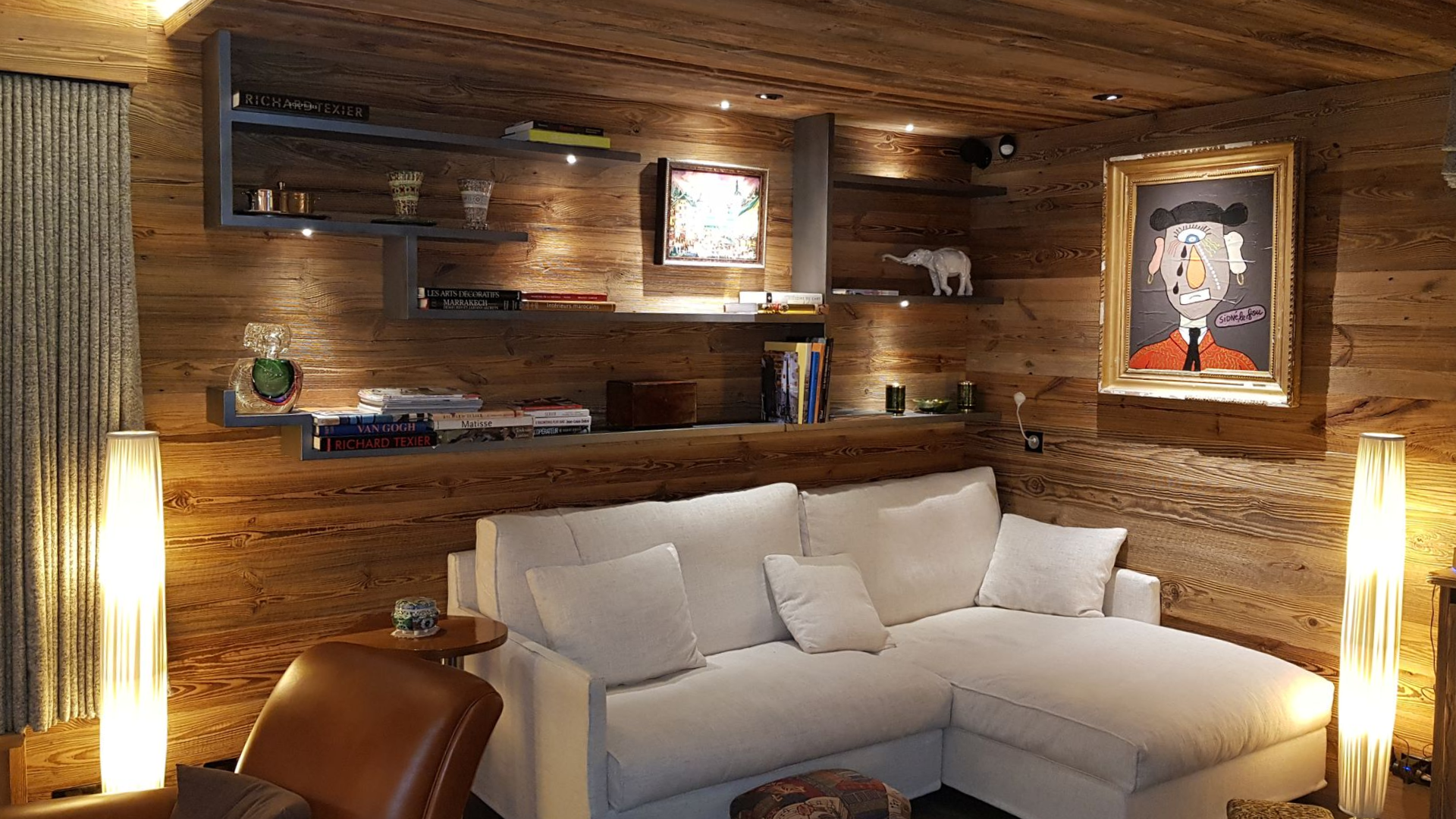 Armoire en bois encastrée dans le mur d'une chambre, partiellement ouverte, avec un lit au premier plan.;