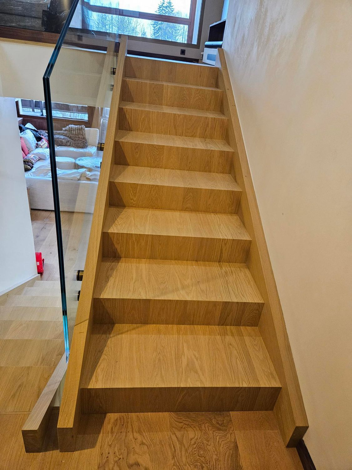 Escalier en bois avec rampe en verre. Intérieur d'une maison.