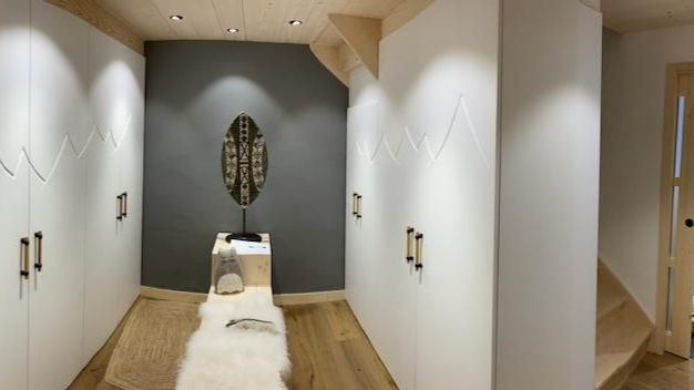 Dressing avec placards blancs, parquet, mur d'accent gris et objet décoratif.