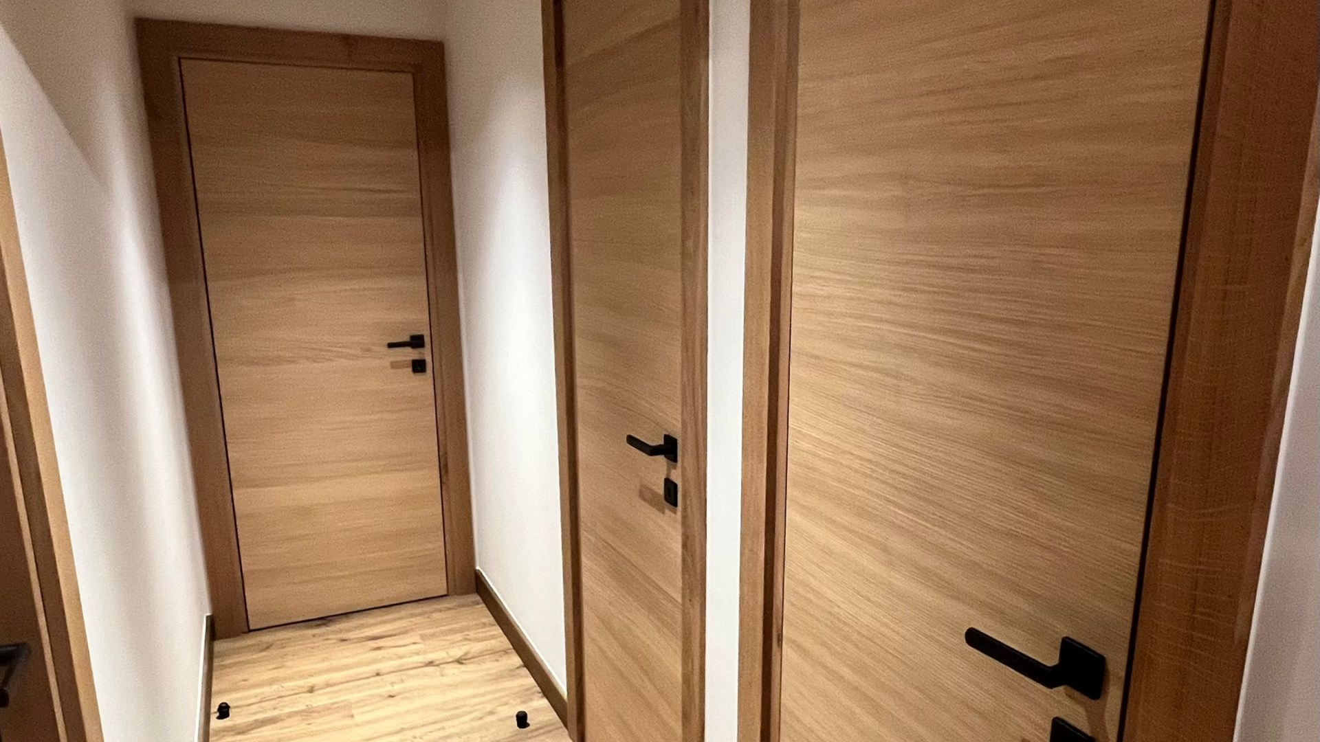 Lits superposés en bois dans une chambre lambrissée. Accès aux lits superposés supérieurs par une échelle.