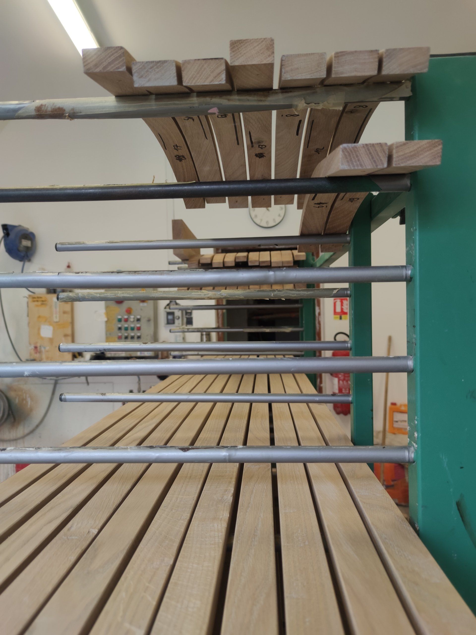 Planches de bois sur un système de convoyeur dans un atelier, prêtes à être transformées.