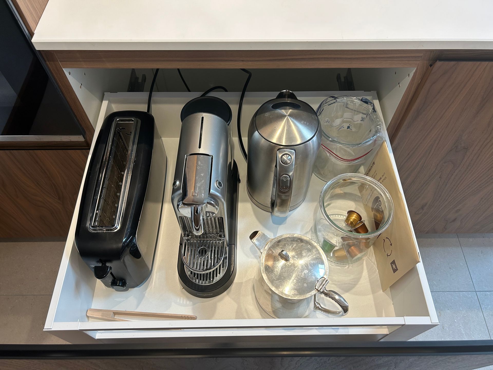 Tiroir contenant un grille-pain, une cafetière, une bouilloire, des récipients en verre et une théière.