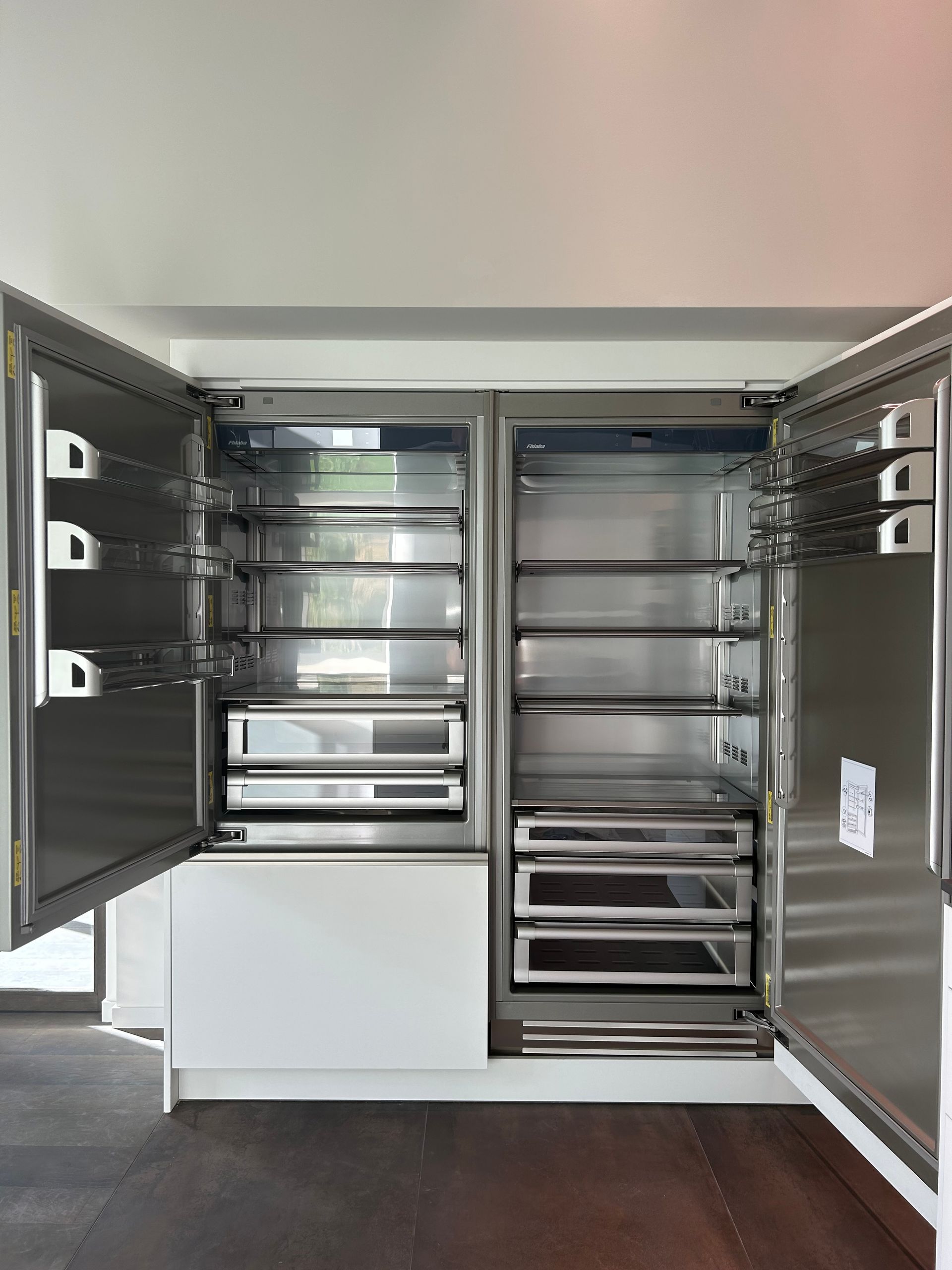 Meuble de cuisine en acier inoxydable avec portes ouvertes, dévoilant étagères et appareils électroménagers.