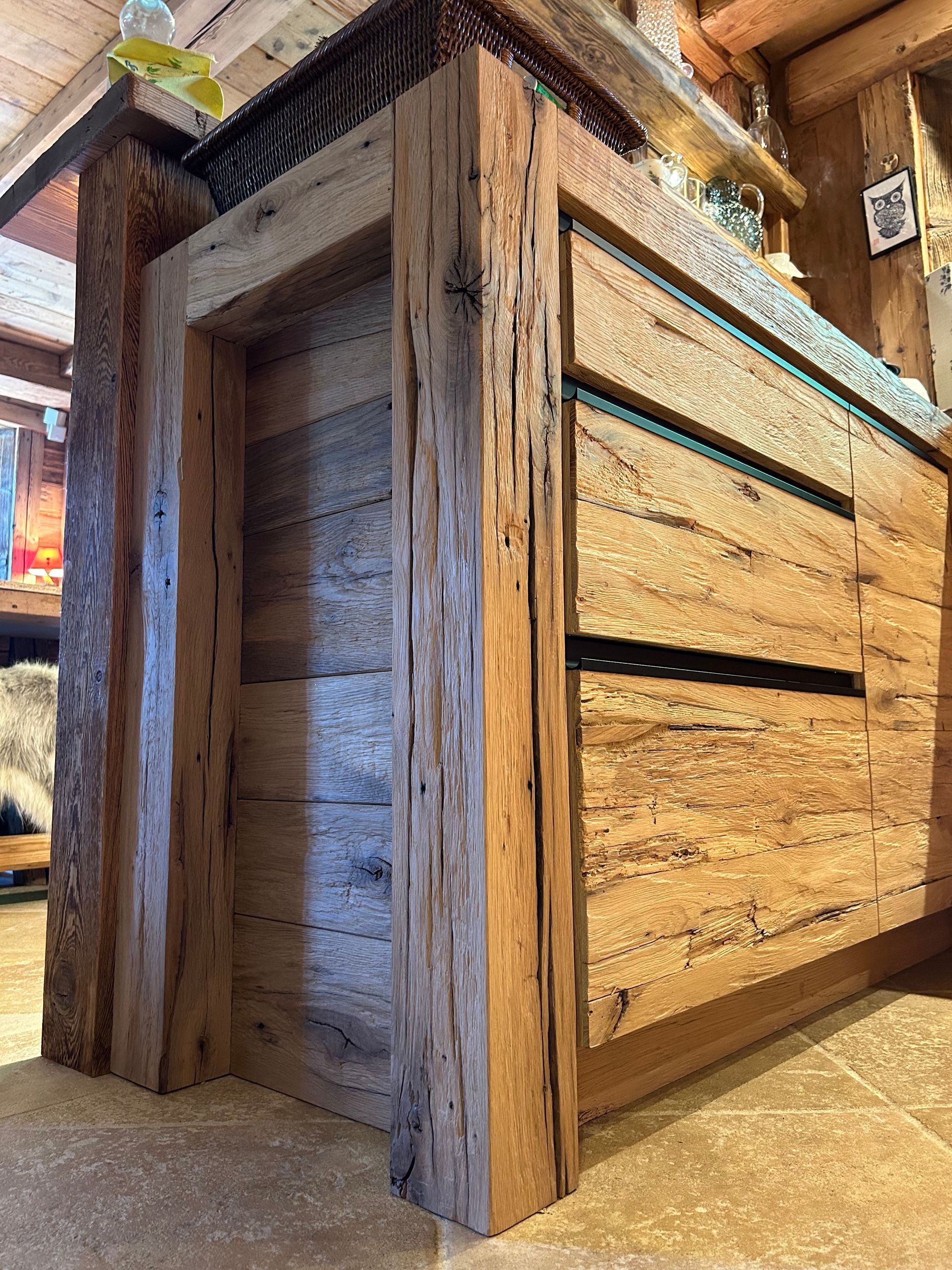 Meuble en bois avec porte ouverte à gauche et tiroirs à droite, dans un cadre rustique.