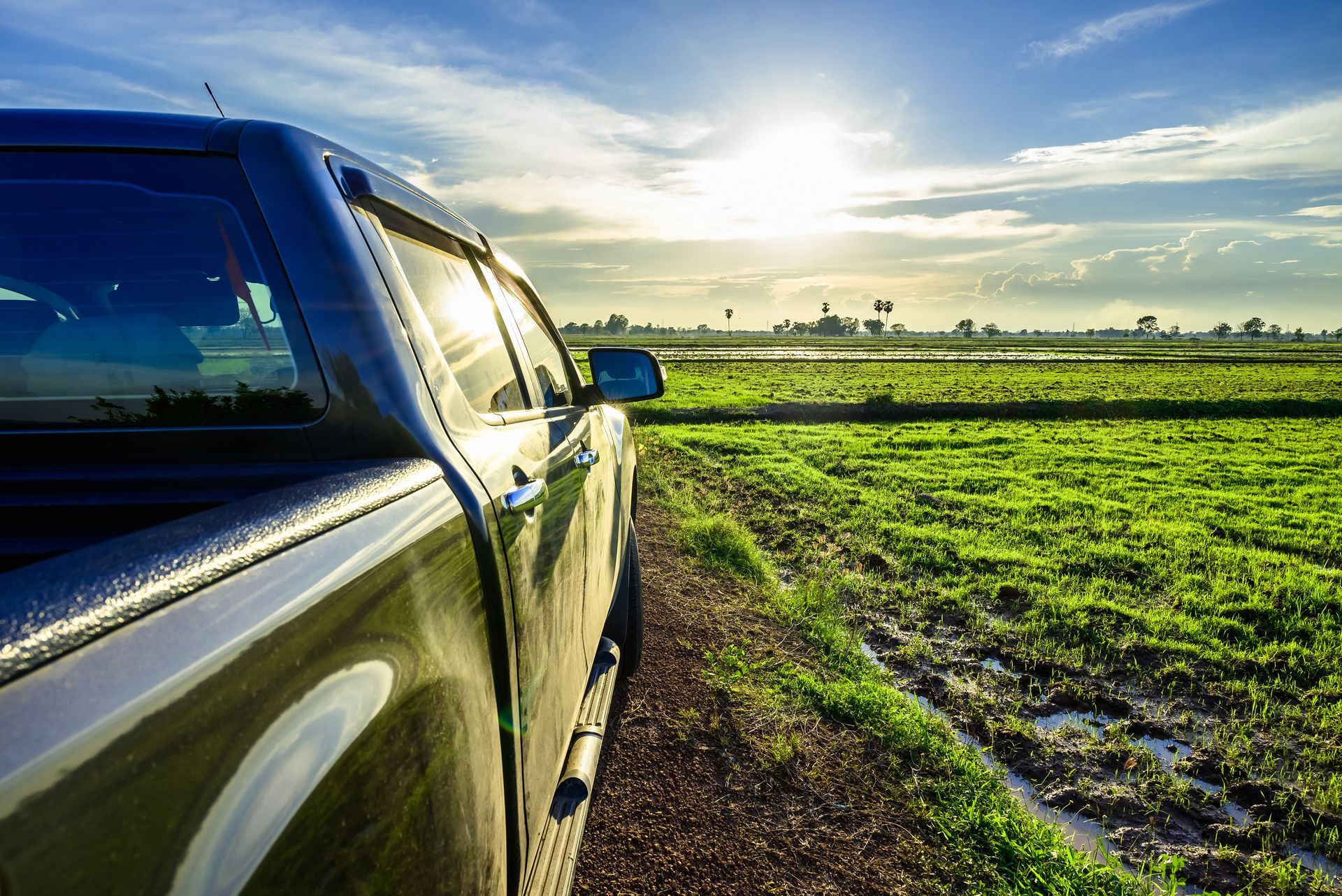 A truck is parked on the side of a road in a field