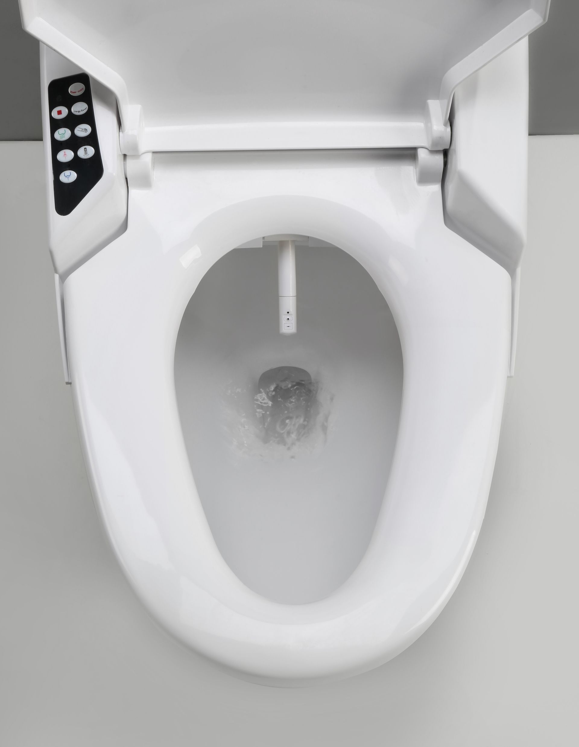Overhead view of a white bidet toilet with a control panel on the left side and water spraying from the nozzle.