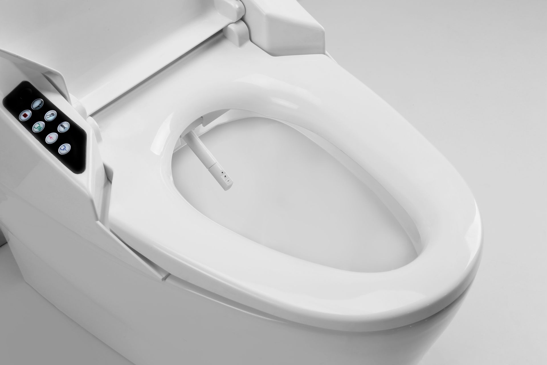 White bidet toilet with attached control panel and nozzle, angled shot, light gray background.