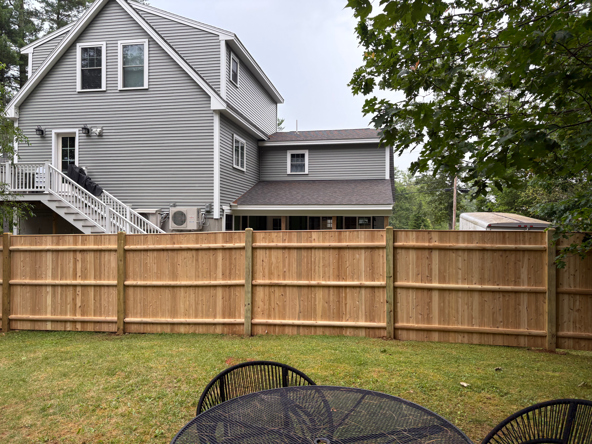 There is a wooden fence in the backyard of a house.