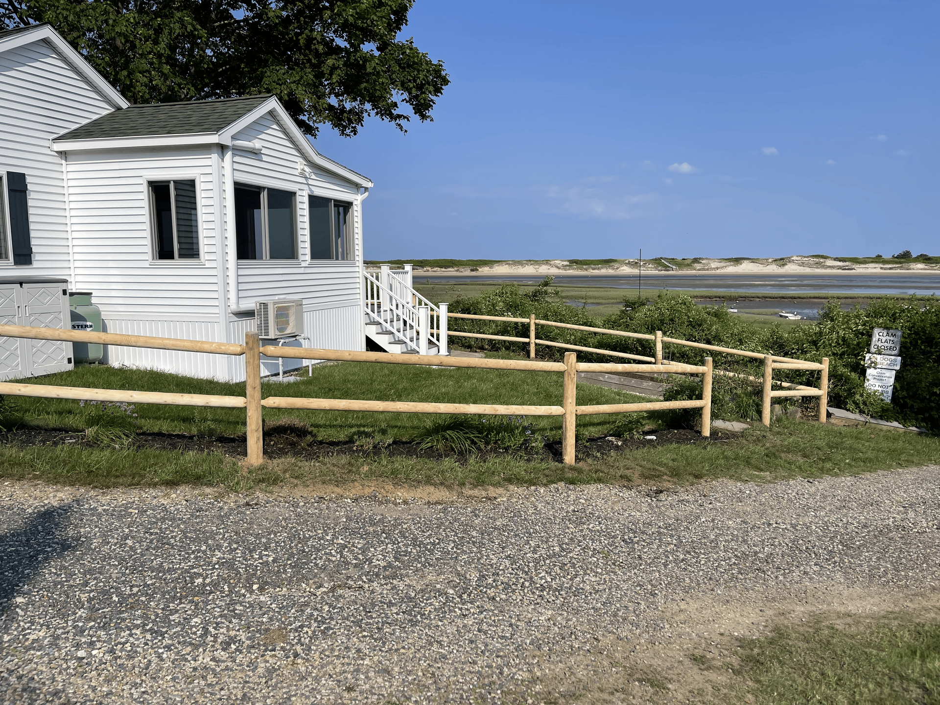 A white house with a wooden fence in front of it.