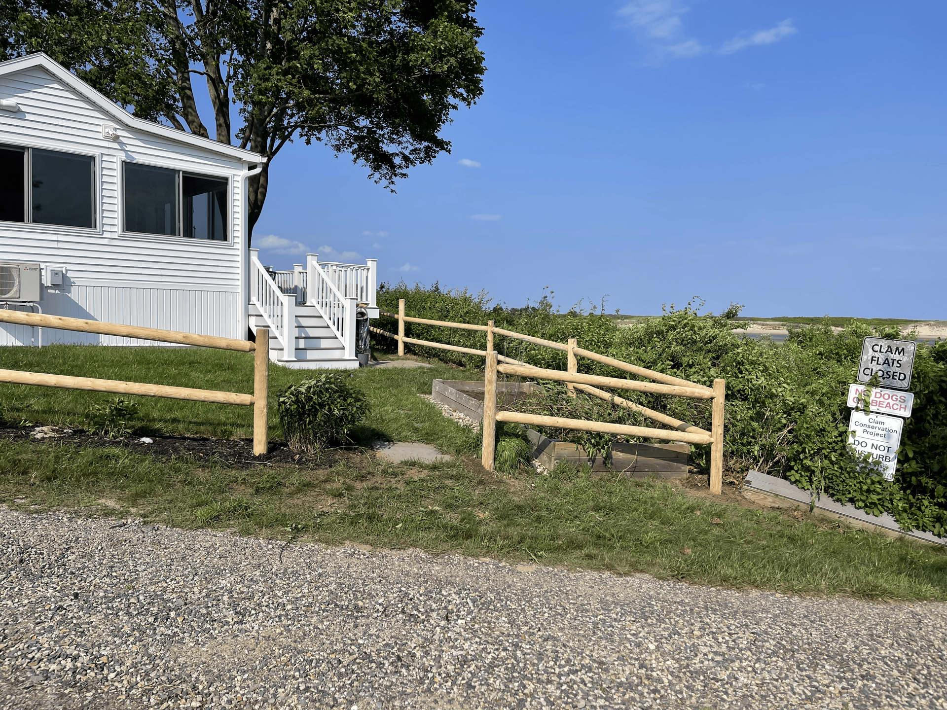 A white house with a wooden fence in front of it.