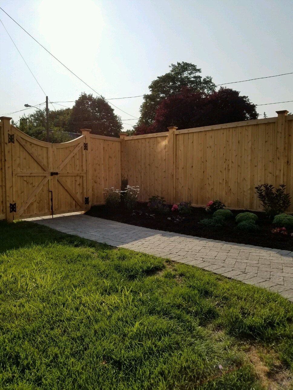 A wooden fence with a gate in the backyard of a house.