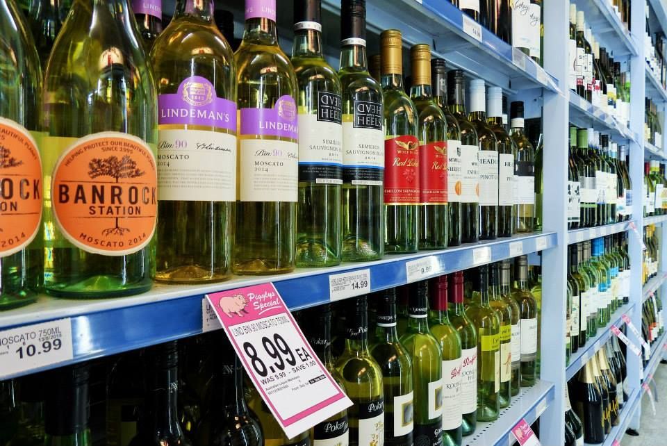 Wine bottles on shelves in a store, many with white labels and various colors. — Pigglys Supermarket, Takeaway & Bottle Shop in The Gap, NT