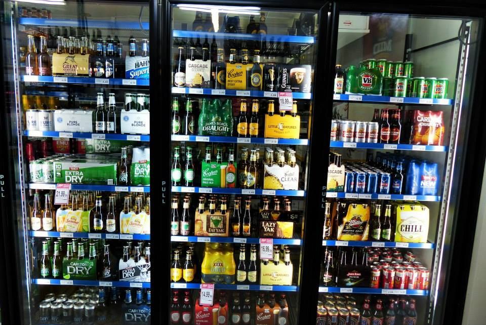 Refrigerated display case filled with various brands of beer bottles and cans. — Pigglys Supermarket, Takeaway & Bottle Shop in The Gap, NT