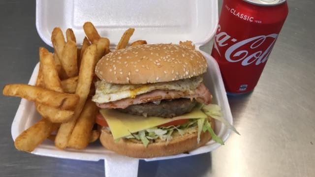 Hamburger with fries and a Coca-Cola can in a styrofoam container. — Pigglys Supermarket, Takeaway & Bottle Shop in The Gap, NT