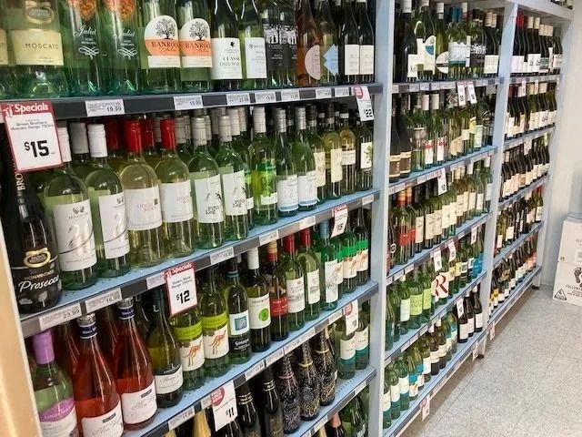 Wine Bottles on Shelves in a Store, Various Colors — Pigglys Supermarket, Takeaway & Bottle Shop in The Gap, NT