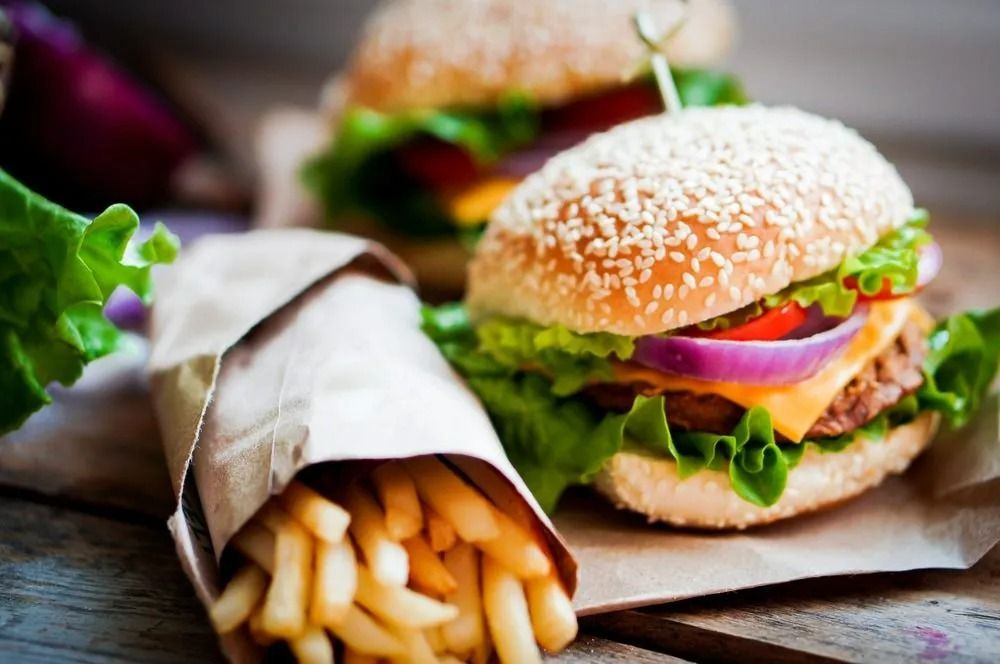 Hamburgers With Fries in Paper Bag on a Wooden Surface — Pigglys Supermarket, Takeaway & Bottle Shop in The Gap, NT
