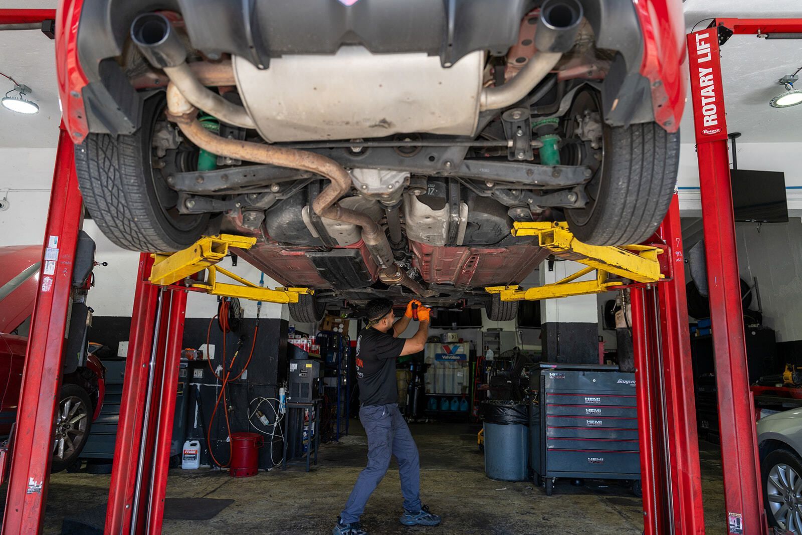 Garage with a Car Lifted on a Two-Post Hoist for Maintenance | Auto Vice