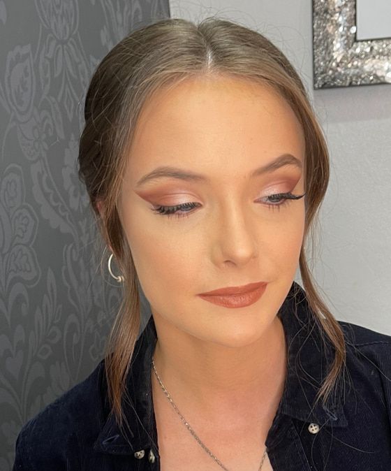 A Woman Wearing A Necklace And Earrings Is Standing In Front Of A Mirror — Envy Cosmetic Collective in Maitland, NSW