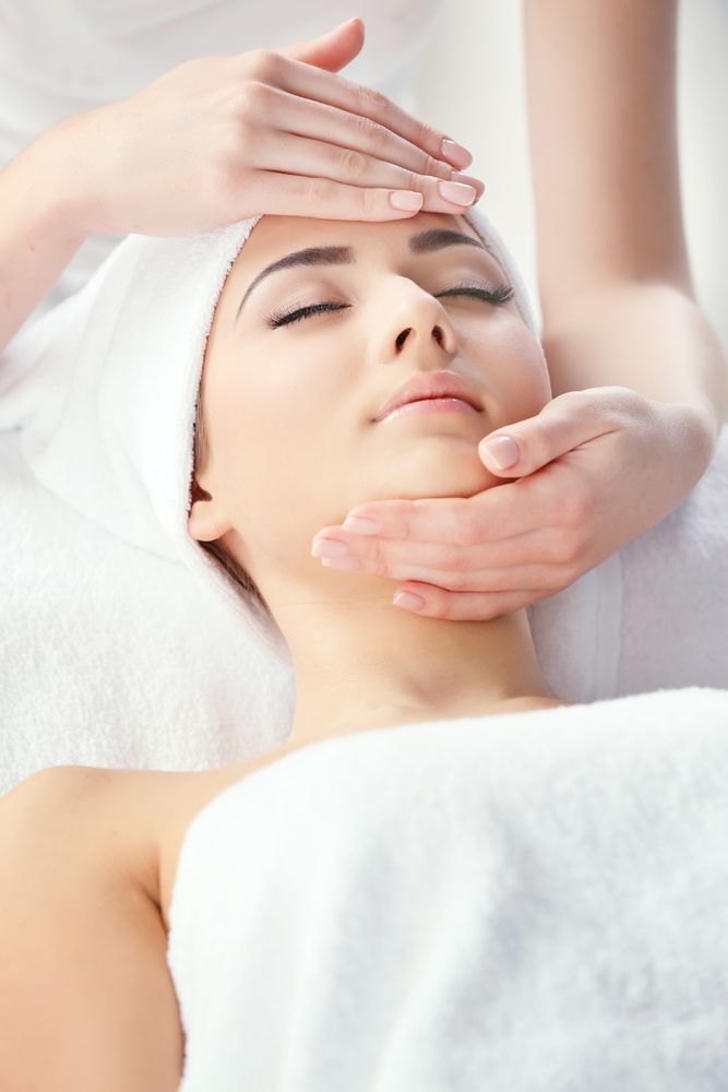A Woman is Getting a Facial Massage at a Spa — Envy Cosmetic Collective in Maitland, NSW