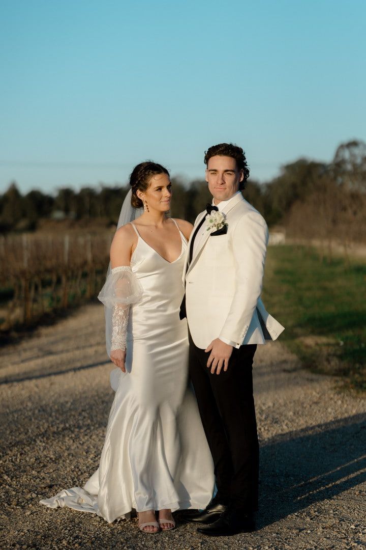 a bride and groom standing in a vineyard 
— Envy Cosmetic Collective in Maitland, NSW