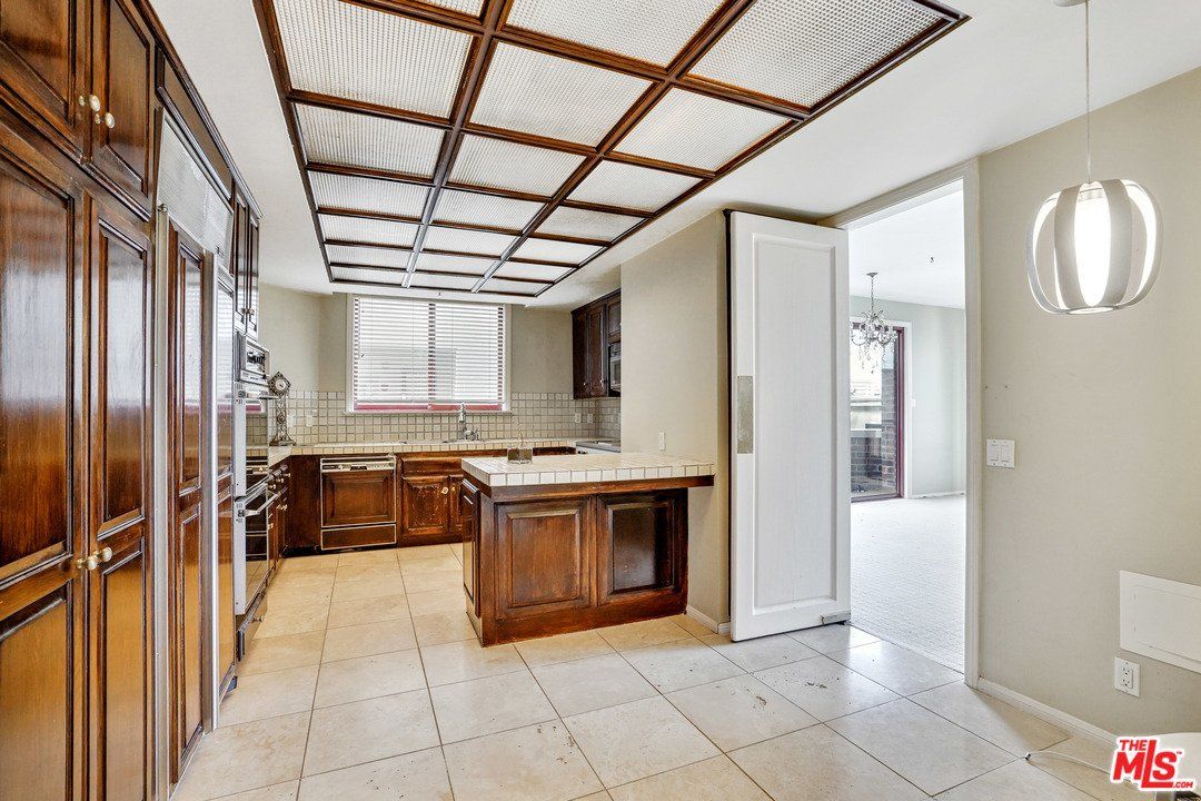 A kitchen with wooden cabinets and a glass ceiling