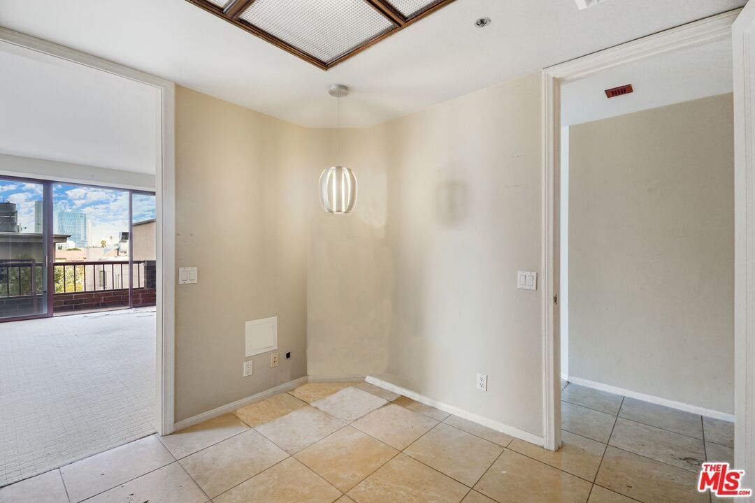 An empty room with a tiled floor and a window