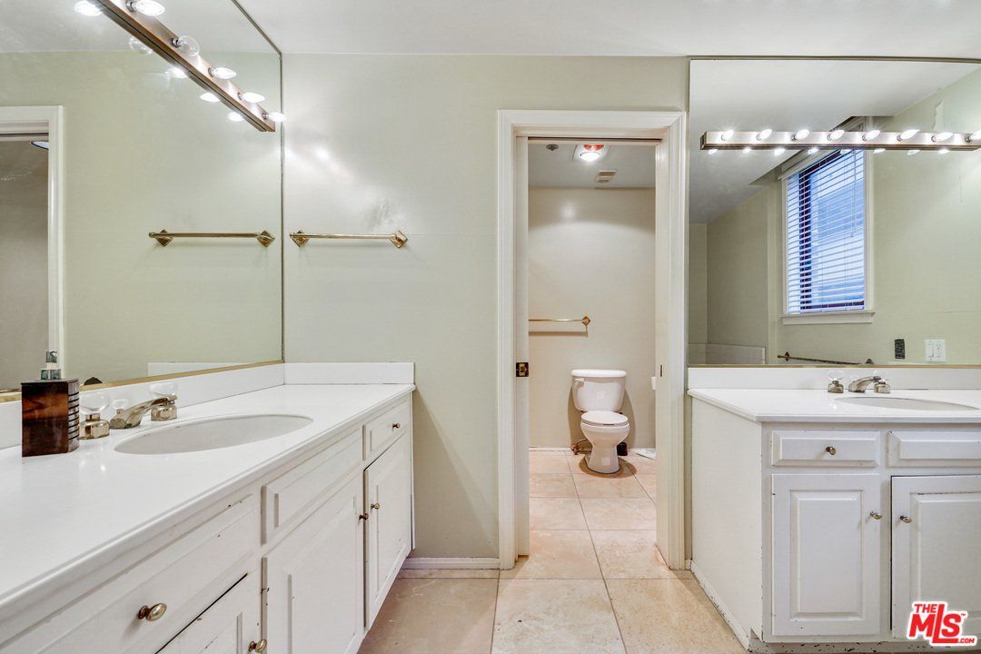 A bathroom with two sinks and a toilet