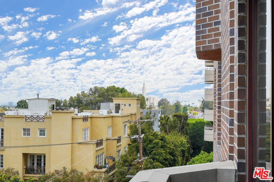 A view of a city from a balcony of a brick building.