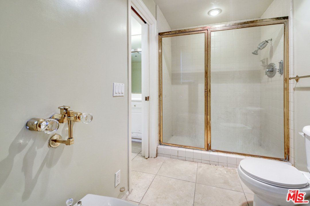 A bathroom with a toilet and a walk in shower.