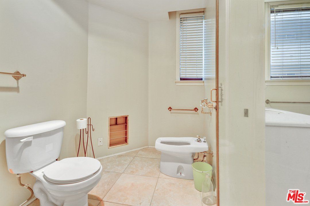 A bathroom with a toilet and a bidet in it