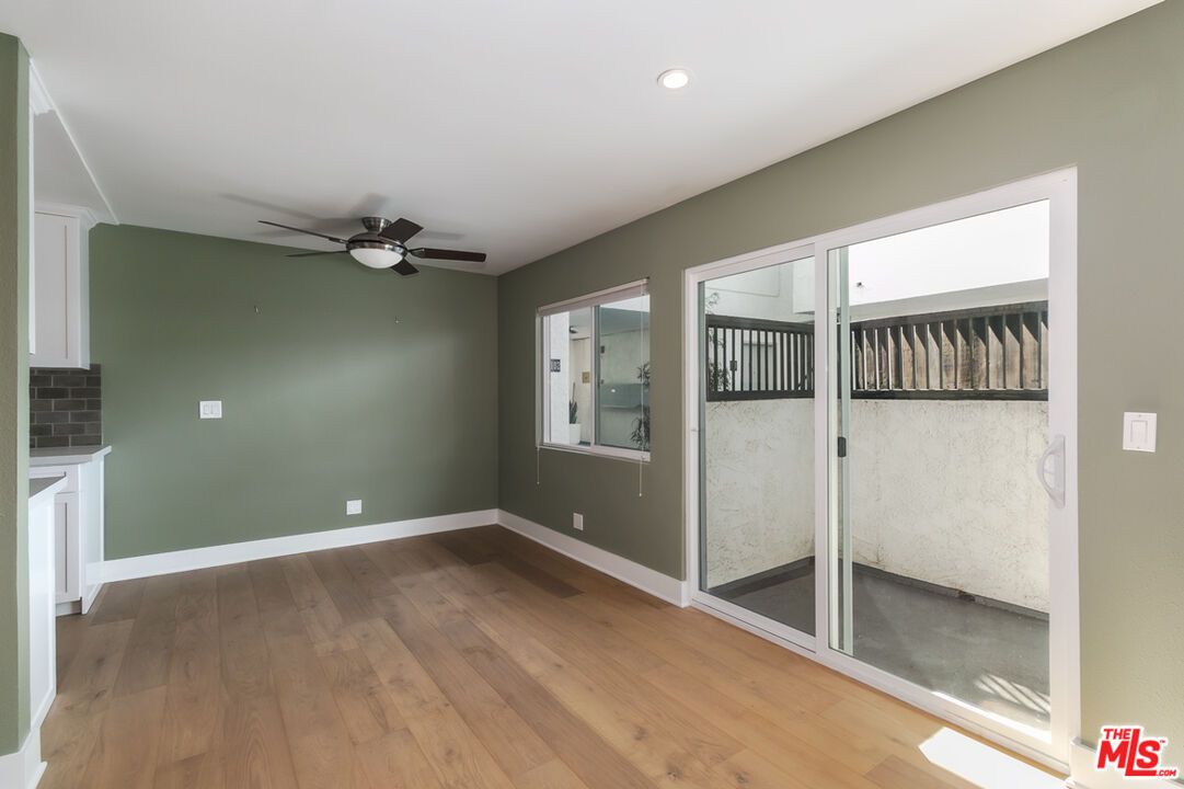 A living room with sliding glass doors and a ceiling fan.