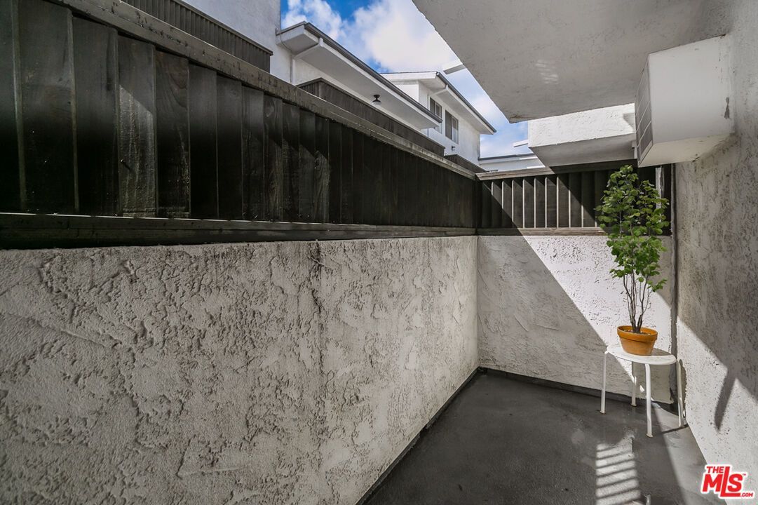 A corner of a building with a fence and a table.
