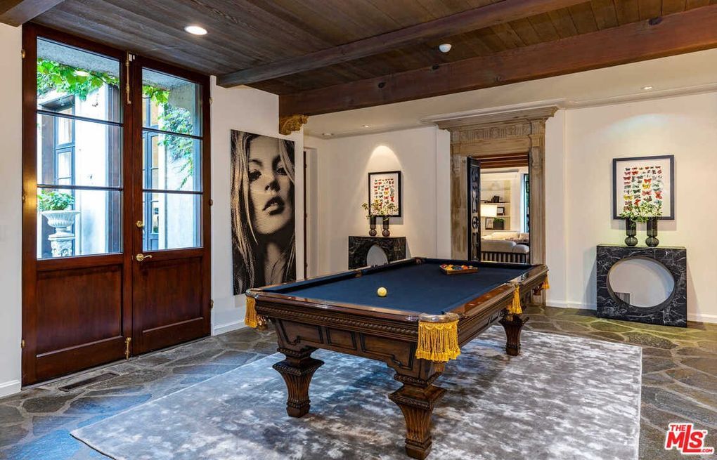 There is a pool table in the middle of the room.