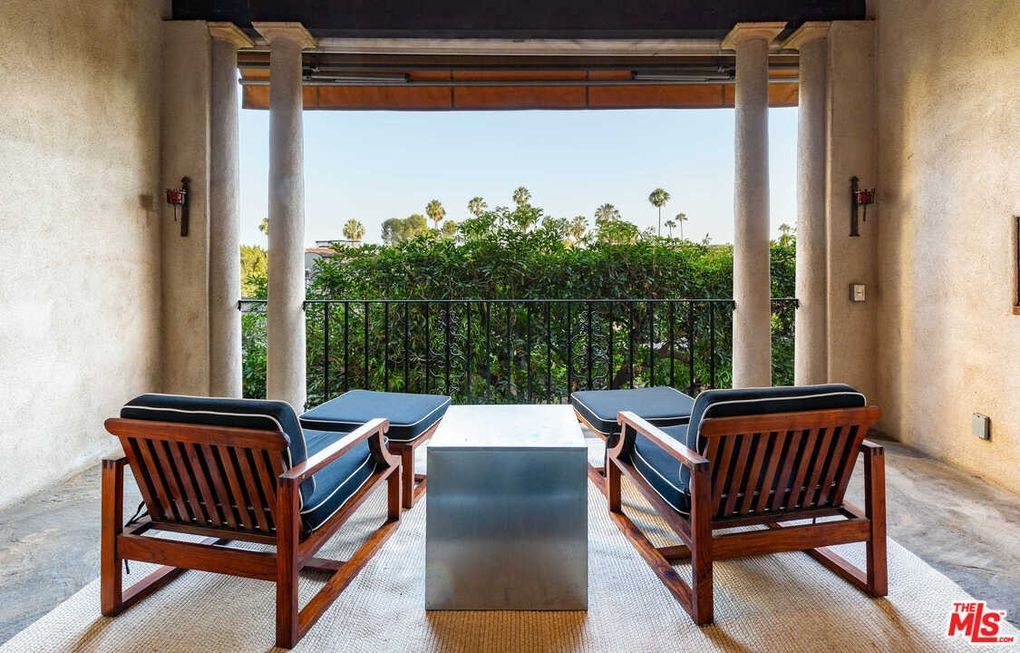 There are two chairs and a table on the balcony.