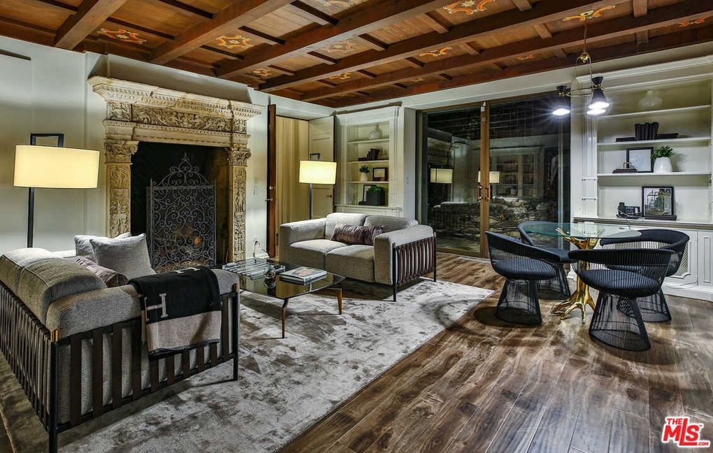 A living room with a fireplace , couch , chairs and a table.