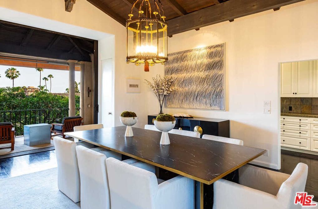 A dining room with a table and chairs and a chandelier.