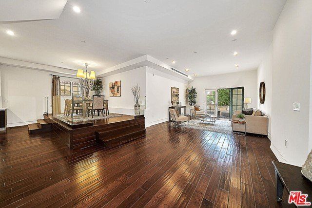A large living room with hardwood floors and a dining room.