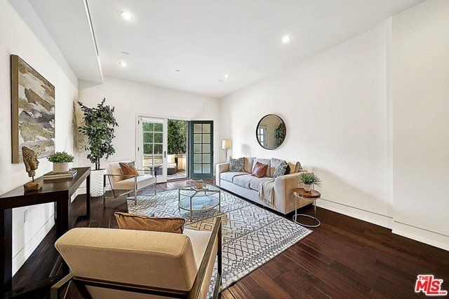 A living room with a couch , chair , table and mirror.